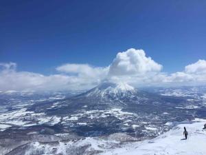 a snow covered mountain with two skiers on top of it at MEGANE HOUSE First floor All private in Rankoshi