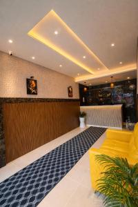 a lobby with a yellow couch and a bar at Heaven Suite in Kalpetta