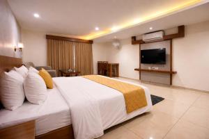 a hotel room with a large bed and a flat screen tv at Heaven Suite in Kalpetta +22 photos