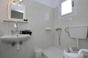 a bathroom with a sink and a toilet and a mirror at Albatros in Skopelos Town +65 photos
