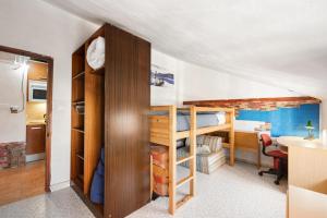 a bedroom with bunk beds and a desk with a table at Buhardilla en centro histórico in Málaga