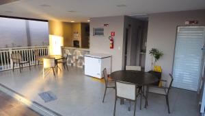 a room with tables and chairs and a kitchen at Apartamento completo no Bérgamo in Feira de Santana