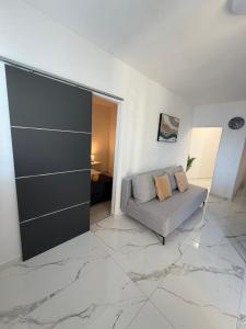 a living room with a couch on a marble floor at Apartments Lory in Rabac