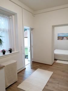 a white room with a bed and a window at Borika Vip Apartments in Mezőkövesd