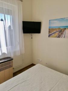 a bedroom with a white bed and a window at Borika Vip Apartments in Mezőkövesd