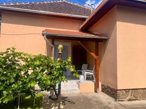 a small house with a front porch with a chair at Borika Vip Apartments in Mezőkövesd
