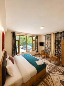 a bedroom with a large bed and a large window at Crest Manali River View in Manāli