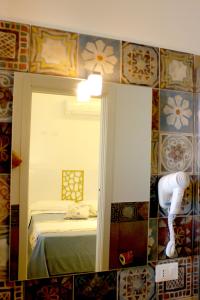 サン・ヴィート・ロ・カーポにあるFra lu Mariの鏡付きのベッドルーム1室、ベッド1台が備わるベッドルーム1室を提供しています。