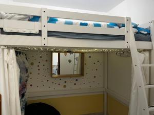 a bedroom with two bunk beds and a mirror at Fenyves Bay Apartman in Balatonfenyves