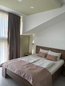 a bedroom with a large bed with two pillows at Villa Aba apartments in Sarajevo