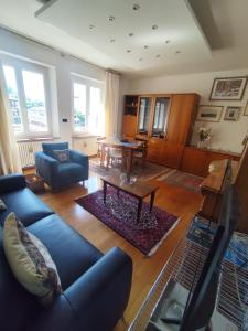 a living room with a blue couch and a table at La place du Coeur in Pont-Saint-Martin