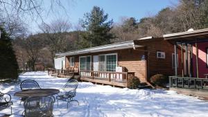 a cabin with a table and chairs in the snow at Pocheon Haneulbat Pension in Pocheon