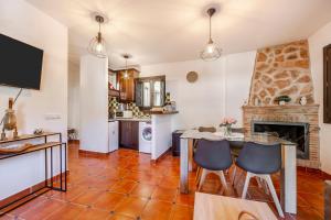 a kitchen with a table and chairs and a fireplace at Tu Descanso en Ohanes in Ohanes