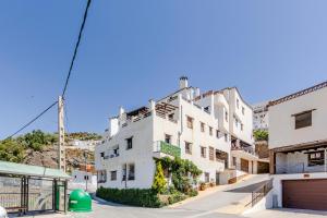 a white apartment building in front of a mountain at Tu Descanso en Ohanes in Ohanes