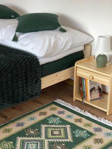 a bedroom with a bed with a table and a rug at Na Młace Apartament z widokiem in Witów