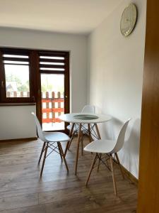 a dining room with three tables and white chairs at Na Młace Apartament z widokiem in Witów