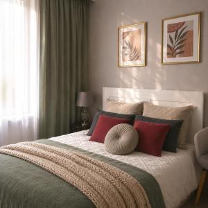 a bedroom with a large bed with red pillows at Narva Vibe Apartment in Narva