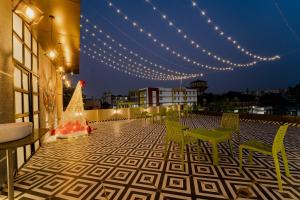 a rooftop patio with a christmas tree and lights at palm hotel mansarovar in Jaipur
