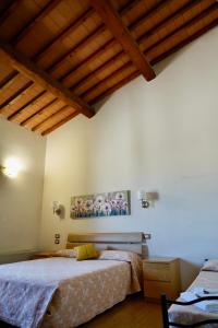 a bedroom with two beds and a wooden ceiling at La Rosa Garden in Campi Bisenzio