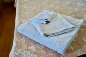 a pile of towels sitting on top of a bed at La Rosa Garden in Campi Bisenzio
