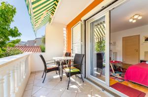 a room with a balcony with a table and chairs at Rooms Nadica in Baška