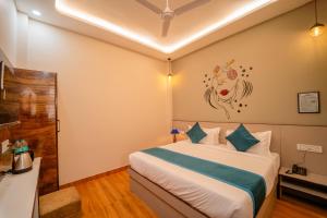 a bedroom with a bed with a painting on the wall at palm hotel mansarovar in Jaipur
