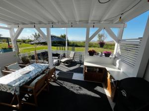 a screened in porch with a table and chairs at Fenyves Bay Apartman in Balatonfenyves