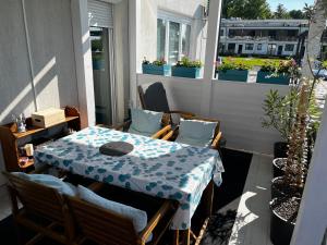 a patio with a table and chairs on a balcony at Fenyves Bay Apartman in Balatonfenyves +18 photos