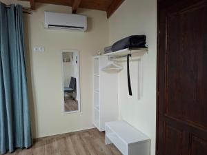 a room with a white closet with a fan on the wall at Terra Solaris Guesthouse in Kissamos