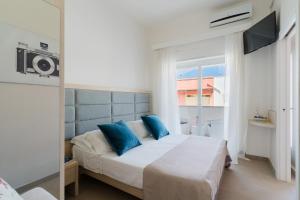 a bedroom with a bed with blue pillows at Baia Di Torre Squillace in Sant'Isidoro