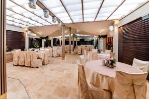 a banquet hall with white tables and chairs at Hotel Regal in Costinesti +170 photos