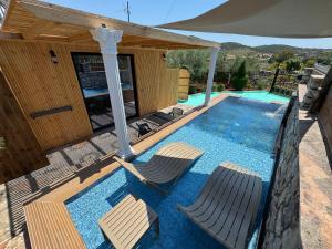 a swimming pool with two chairs and an umbrella at Infinity Suites Pushi in Ksamil