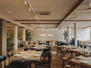 a restaurant with wooden tables and chairs and tablesearcher at Hotel Spa Mediterráneo Park in Roses