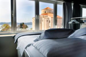 a bedroom with two beds and a window with a church at Boutique Hostel Forum in Zadar
