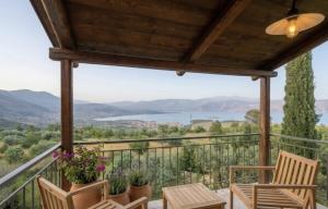 a balcony with chairs and a view of a lake at Olive House Galaxidi in Galaxidi