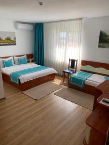 a hotel room with two beds and a desk at Marina House in Sulina
