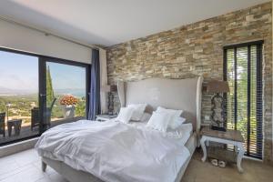 a bedroom with a white bed and a brick wall at Sa Punta 99 F2 in Begur +35 photos