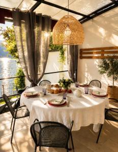 a dining room with a white table with chairs and aoit at Diamante sull'acqua in Sale Marasino +28 photos