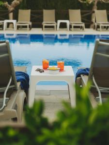 a table with a plate of food on it next to a pool at Hotel Spa Mediterráneo Park in Roses +26 photos