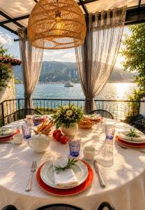 a table with a white table cloth with a view of the water at Diamante sull'acqua in Sale Marasino