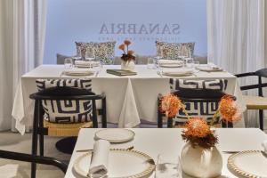 a white table with chairs and tables with plates and vases at Barceló Santa Cruz Contemporáneo in Santa Cruz de Tenerife