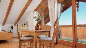 a dining room with a wooden table and chairs at Ferienwohnungen Stecher in Bad Endorf