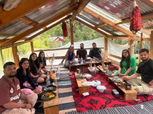 a group of people sitting around a table in a tent at Meet by cooincidence homestay - A place of peace and nature in Shangarh