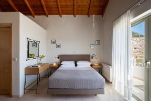 a bedroom with a bed and a mirror and a window at Anassia Villas in Nafplio