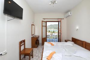 a bedroom with two beds and a television on the wall at Albatros in Skopelos Town