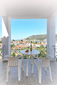 a white table and chairs on a balcony with a view at Albatros in Skopelos Town