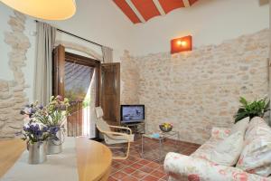 a living room with a couch and a tv at Masia Casa Roja in Banyeres del Penedes