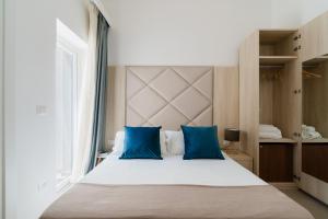 a bedroom with a large bed with blue pillows at Baia Di Torre Squillace in Sant'Isidoro +26 photos