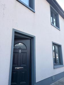 a black door on the side of a white building at Double en-suite in Glin
