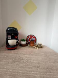 a coffee maker sitting on a counter next to a coke sign at Apartament Iasmina 2 in Petroşani
